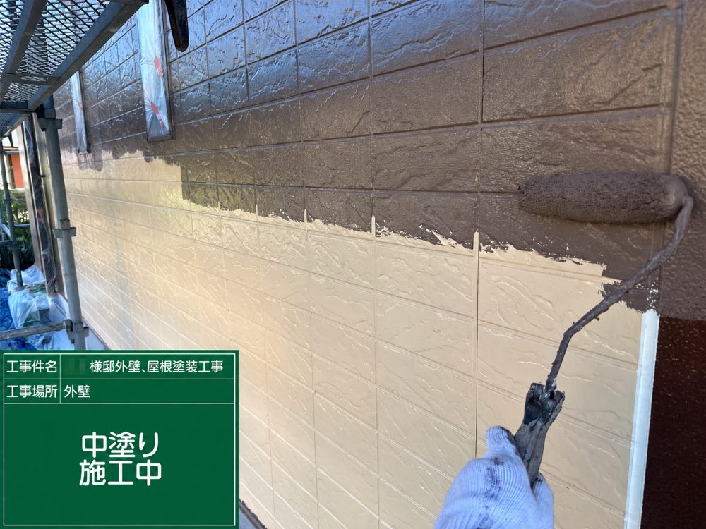 外壁の中塗り施工中の写真